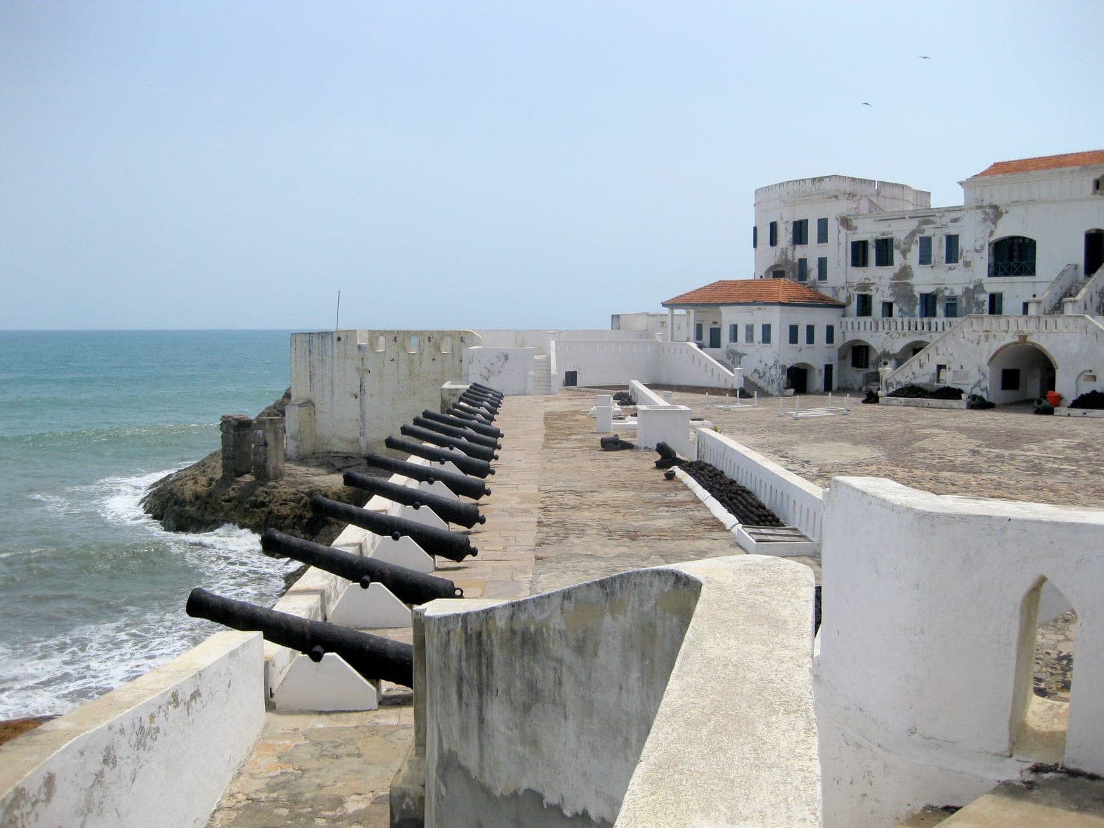 Cape Coast Castle courtyard and cannons beside the Atlantic Ocean